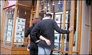 Young couple looking in estate agent's window
