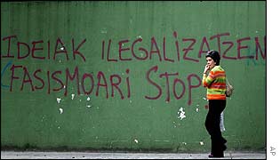 Passer-by walks past a wall painting which says (in Basque) 'Ban on ideas, stop fascism', in Tolosa, northern Spain