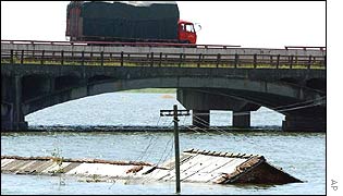 Lorry passes over a bridge above a flooded river