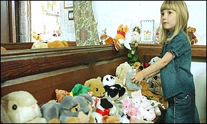 Child looks at the array of toys on a church bench