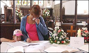 Woman signs book of condolence in St Andrews Church