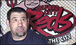 Karl Harrison sits in front of a Salford hoarding during the news conference to announce his arrival 