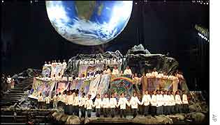Choir performs under an image of the globe
