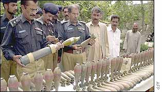 Pakistani policemen inspect arms cache recovered near Afghan border in another raid
