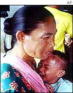 A Filipino woman cuddles her crying child as their passenger ferry ship docks in Zamboanga, southern Philippines, from Malaysia 