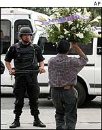 Police officer guards entrance to cemetery
