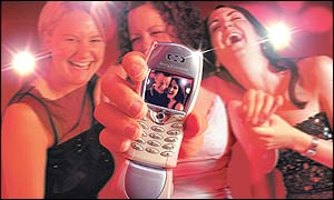 Women in a nightclub with a mobile phone and picture message