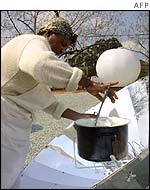 A woman cooks using a solar oven