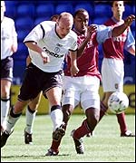 Bolton's Simon Charlton (left) holds off the challenge of Darius Vassell