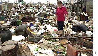 A woman surveys the typhoon debris