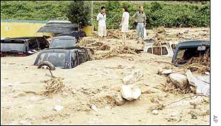 Residents look at cars in mud at Tonghae, east of the capital Seoul