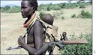 Ethnic Dinka woman with machine gun and baby