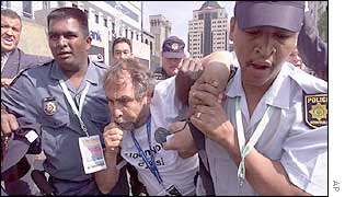 Police remove a Greenpeace protester who is blowing a whistle