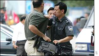 A Chinese policeman blocks a journalist