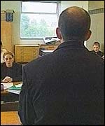 A male teacher teaches a classroom of children