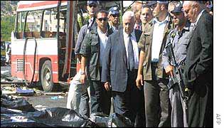 Sharon visiting the scene of a suicide bombing in June