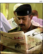 An Iraqi army captain reads the news
