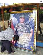 Shopkeeper dusts down portrait of Tiger leader Prabahkaran in Kilinochchi 