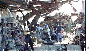 Palestinians inspect the rubble of Mohammed Frainah's metal workshop after it was hit by Israeli helicopters in Khan Younis refugee camp 