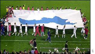 Players carry a flag showing an undivided Korean peninsula
