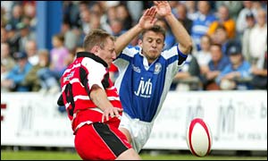 Bridgend scrum-half Huw Harries charges down Gary Armstrong's kick to score against Borders