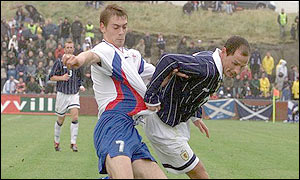 Scotland's Allan Johnston fights to keep the ball as the Faroe Islands press forward