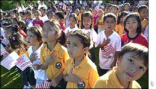 Children watch as the US flag is raised in Guam
