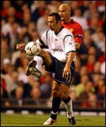 Bolton's Youri Djorkaeff maintains possession despite close attention from Rio Ferdinand of Manchester United