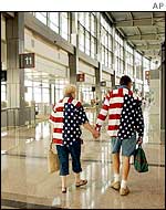 Passengers in patriotic colours make their way past empty gates at Austin Bergstrom International Airport, 11 September 2002