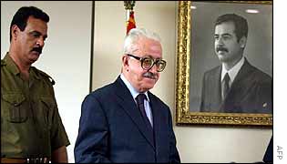Tariq Aziz (centre) arrives for news conference