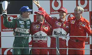 Eddie Irvine on the Monza podium with Rubens Barrichello, Michael Schumacher and Ferrari chief designer Rory Byrne