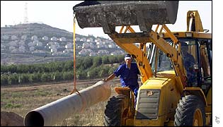 Bulldozer works on Lebanese water project with Metulla settlement in the background