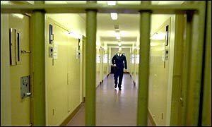 Prison officer seen through bars of a jail