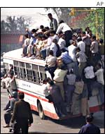 Crowd board a bus on both the inside and outside