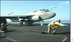 An EA-6B Prowler launches off a catapult from the flight deck of a US aircraft carrier