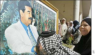 An Iraqi man kisses a huge framed portrait of President Saddam Hussein during celebrations in Baghdad 