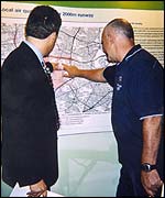 People examine a large diagram of the plans