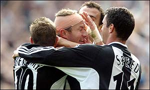 Shearer (centre) is mobbed after Newcastle's second