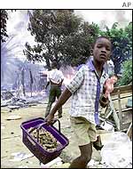 A boy by a burning shack