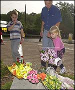 Children place flowers near the police road block, Yateley Heath, Hampshire
