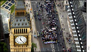 Marchers walk next to Houses of Parliament