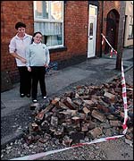 Pat Battison and daughter Sophie, 9, survey their smashed chimney