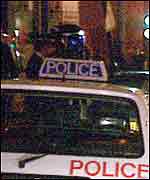 Police officers standing in front of a police car