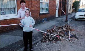 Pat Battison and daughter Sophie, 9, survey their smashed chimney in Bloxwich, West Midlands