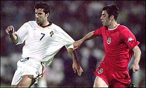 Mark Delaney in action against Portugal's Luis Figo