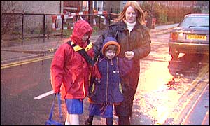 Woman escorts children across road