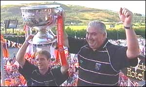Kieran McGeeney and Joe Kernan show off Sam Maguire on Monday evening
