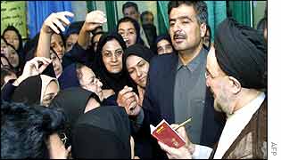 President Khatami (right) signs autographs for schoolgirls