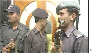 Pakistani policemen stand guard at the door of the Christian charity after the attack