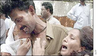 Man consoles women grieving over the death of a relative in the attack